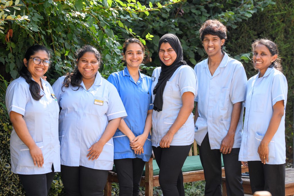 six team members standing outside and smiling at the camera